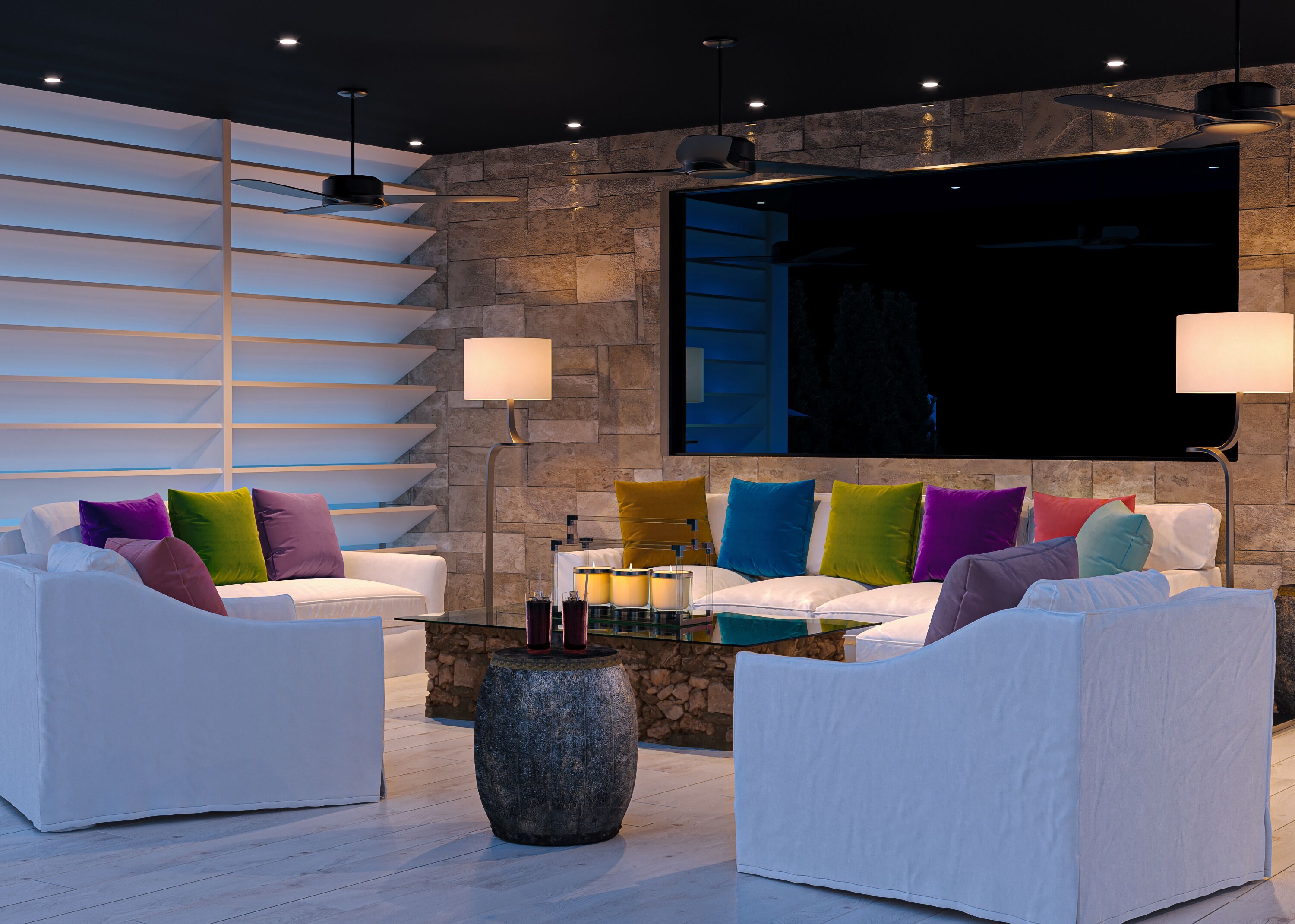 A modern living room with white sofas, colorful cushions, a glass coffee table, and a stone accent piece.