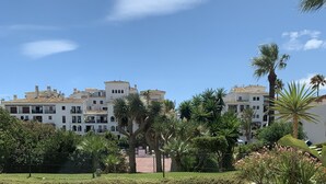 A courtyard with tiled flooring, a neatly trimmed hedge, and a palm tree. - La Duquesa Port, South facing ground floor apartment, with large terrace (Puerto Duquesa)