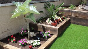 Ein Garten mit erhöhten Beeten und verschiedenen Pflanzen und Blumen.