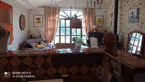 A cozy room with a large window, a wooden ceiling, and a tiled floor. - Shed renovated with charm, swimming pool and bucolic garden at the foot of the Luberon (Cheval-Blanc)