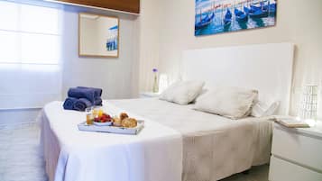 Enjoy a restful stay in this stylish room featuring a comfortable bed, a bedside table, and a beautiful coastal painting.