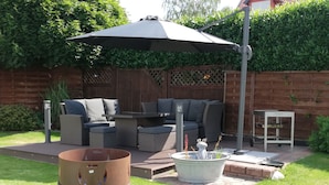 A patio with outdoor furniture, a grill, and a table with a metal stand. - Cozy vacation home for up to 8 pers., 4 bathrooms, W- Lan, sauna house, dog allowed  (Trendelburg)