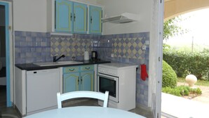 Una cocina compacta con armarios azules, una encimera blanca y un horno pequeño.