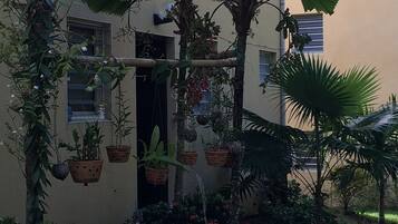 A building with a garden area featuring potted plants and flowers.