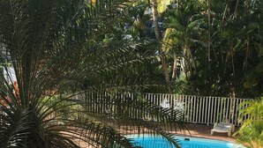 A swimming pool surrounded by palm trees and white lounge chairs. - CHARMING T3 with TERRACE and magnificent sea view (Le MARIN)