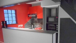 A compact kitchen with a microwave, a coffee maker, and a window with a view. - duplex apartment bis (Vannes)