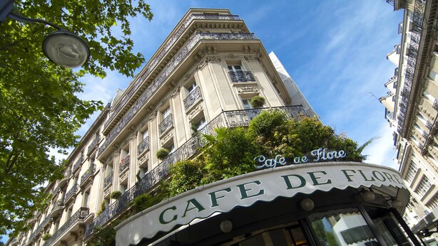 A cafe with a classic architectural style, featuring ornate balconies and a sign that reads "Cafe de Flore". - LUXURY SECURED SAINT GERMAIN DES PRES (968 Sqf) (Paris)