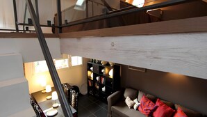 Un espacio habitable estilo loft con una mesa de comedor, sofá y estanterías.