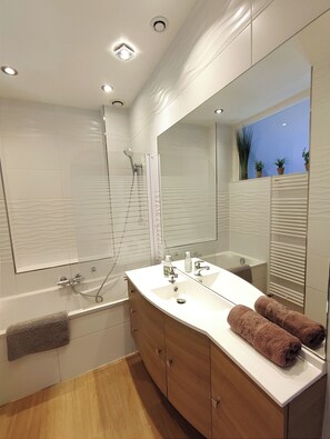 Bañera con ducha, toallas, papel higiénico