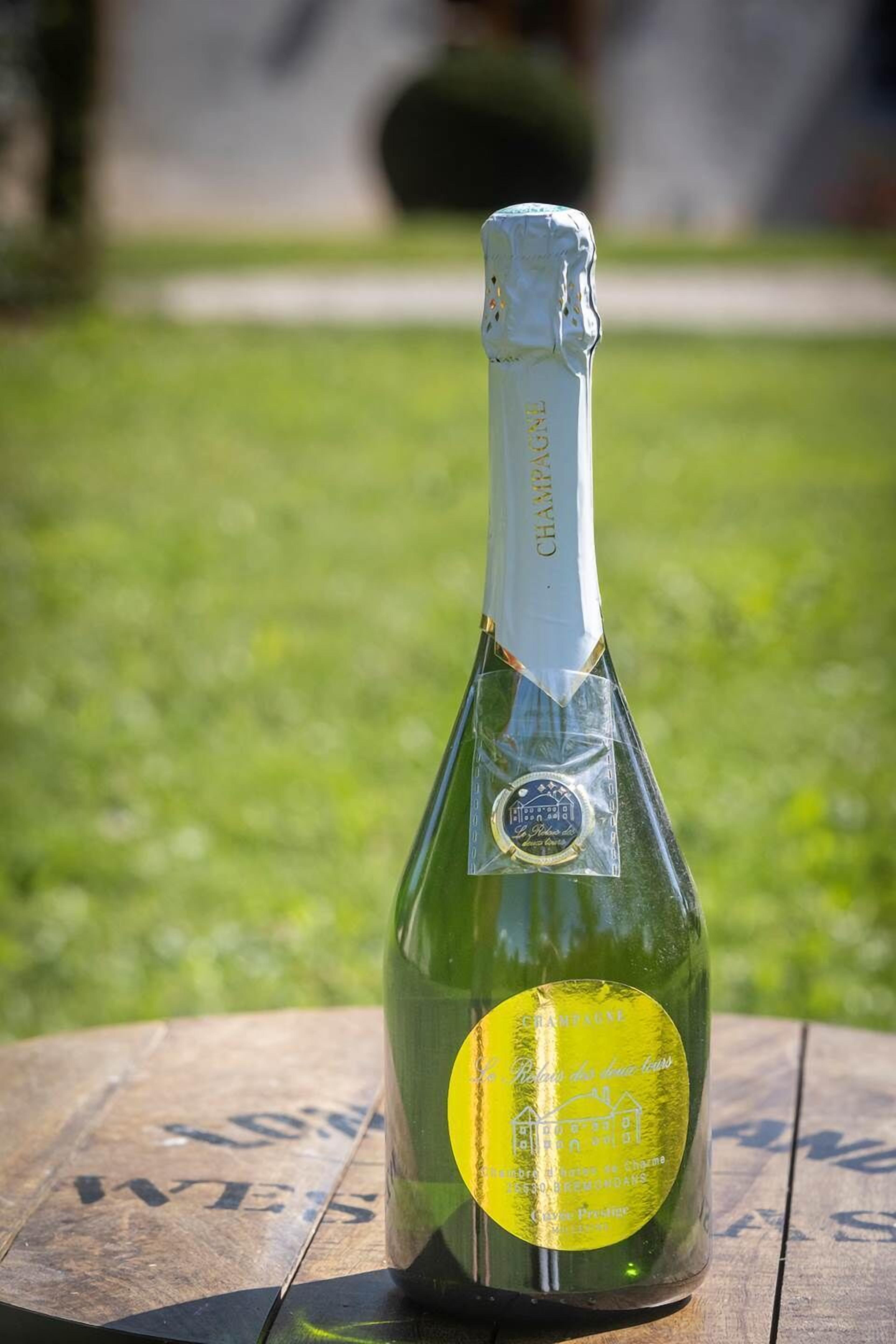 Eine Flasche Champagner auf einem Holztisch im Freien.