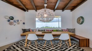 A dining area with a wooden table, white chairs, a patterned rug, and a decorative ceiling light. -  5 bdrm, 3.5 bth Private Luxury retreat with mountain views! Permit #068365 (La Quinta)