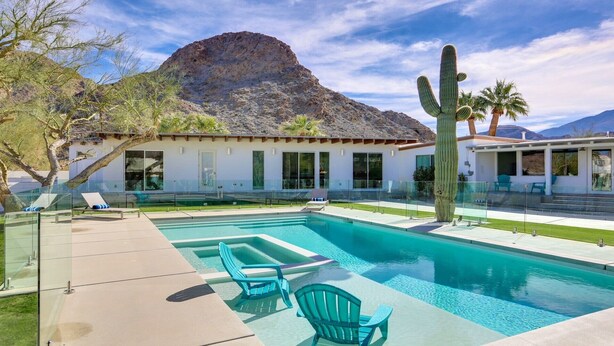 A modern pool area with clear blue water, two lounge chairs, and a mountain backdrop. -  5 bdrm, 3.5 bth Private Luxury retreat with mountain views! Permit #068365 (La Quinta)