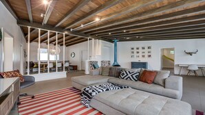 A spacious living area with a high ceiling, a sofa set, a dining area, and a wall-mounted bull's head decoration. -  5 bdrm, 3.5 bth Private Luxury retreat with mountain views! Permit #068365 (La Quinta)