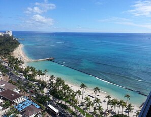 A coastal view with a beach, palm trees, and a pier extending into the ocean. - Foster Twr 2504A NEW REMODEL 1 BR/1BA 25th FLOOR Panoramic View Ocean & Mountain (Honolulu)