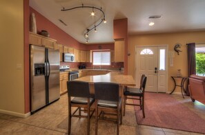 Enjoy cooking in this well-equipped kitchen with a central island, stainless steel appliances, and a large window.