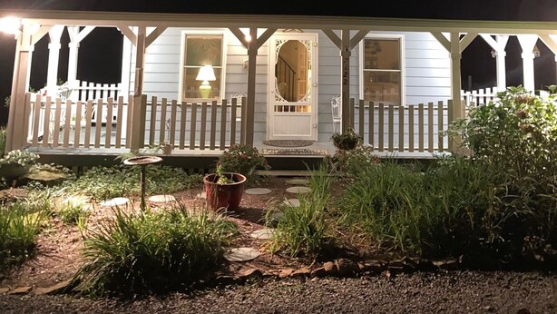 A house with a porch, a circular window, and a number '22' on the wall.