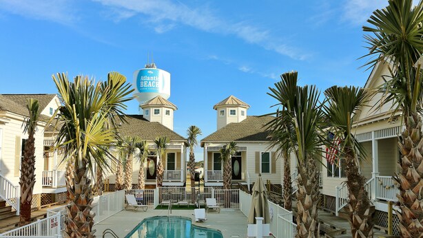 Un resort con piscina, palmeras y un tanque de agua con la leyenda 'Atlantic Beach Carolina del Norte'.