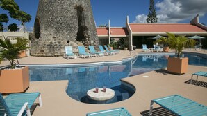 A swimming pool with lounge chairs and a stone structure.