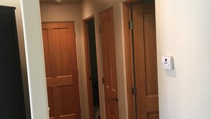Un pasillo con puertas de madera y piso de baldosas.