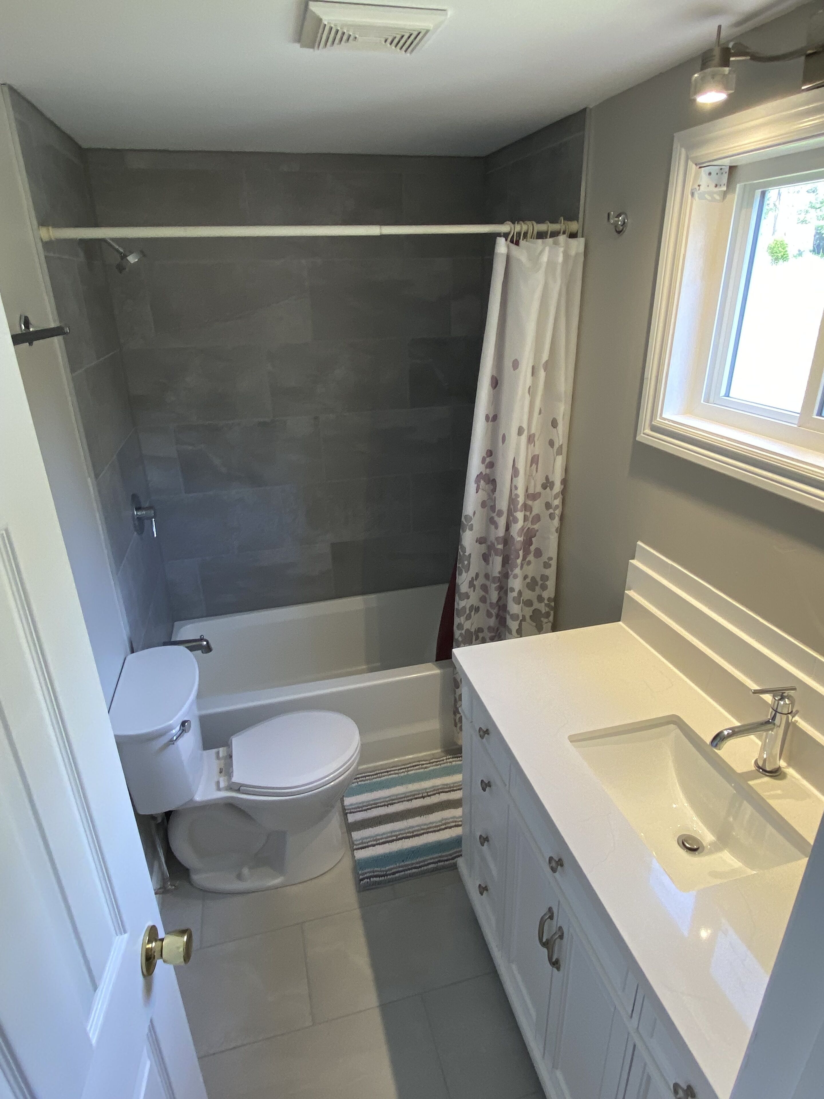 A bathroom with a bathtub, toilet, and sink.