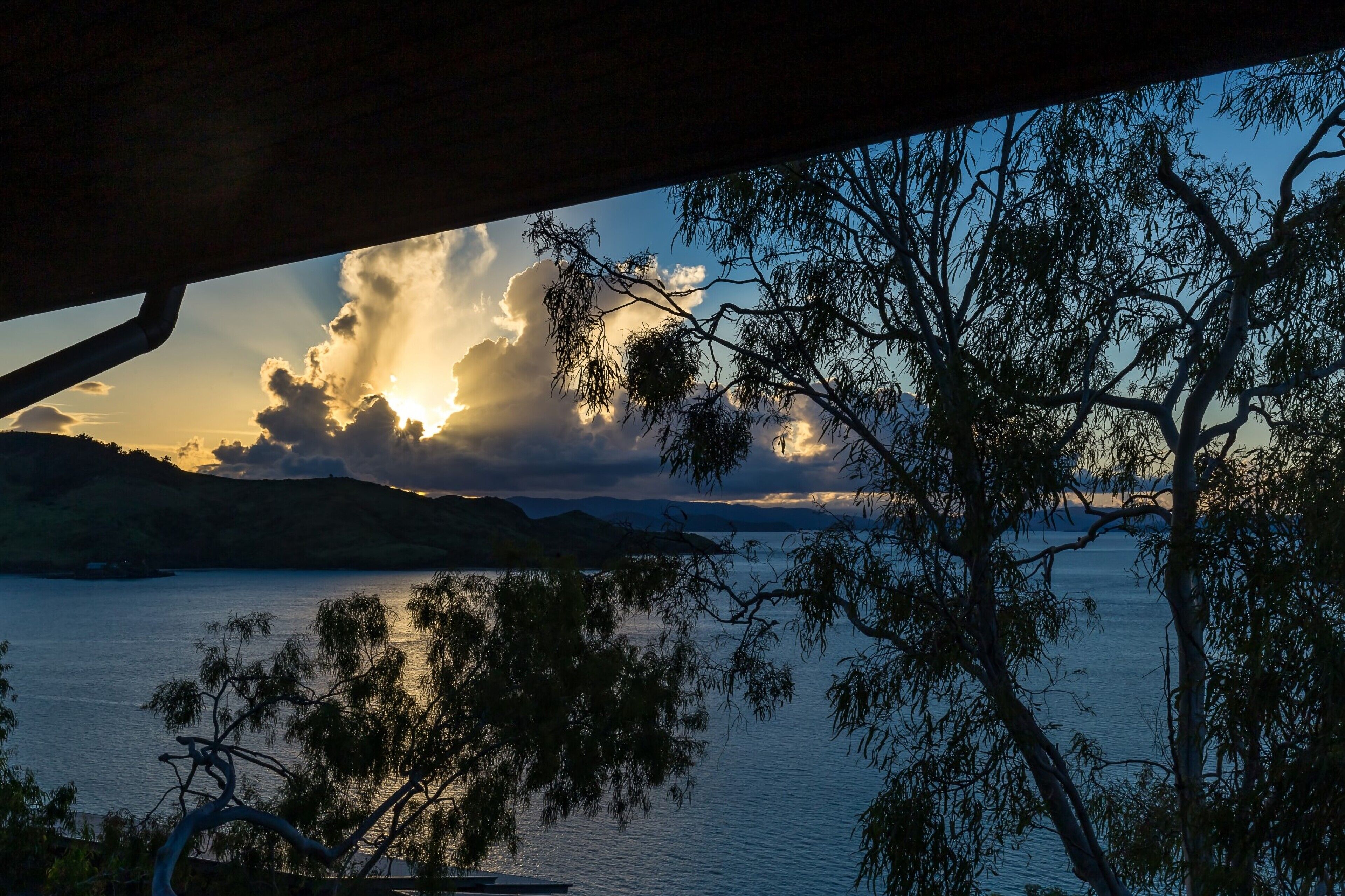 A view of a lake with trees and hills in the background.
