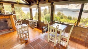 A cozy cabin with a fireplace, wooden furniture, and a scenic lake view.