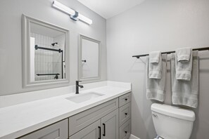 A bathroom with a white sink, a mirror, a toilet, and a towel rack. - Newly remodeled- Panoramic Views- Last Minute Discount (San Diego)