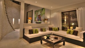 Una sala de estar moderna con un sofá modular, una mesa de centro y una escalera.