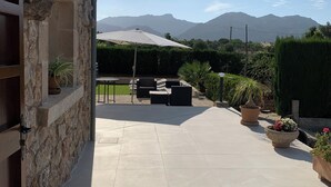 A patio area with stone walls, outdoor seating, and potted plants. -  VILLA CAN TOMI quiet farm house, private parking, wifi, gardens. (pollensa)