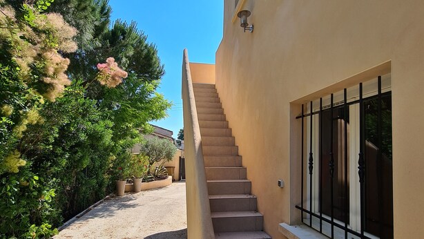 A staircase leading to a building with a window and a door.