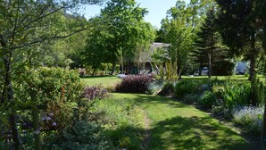 A garden with a path leading to a building with a green door. - Comfortable Barn, Ashdown Forest, Fantastic Local Pub, Excellent For Walkers (Danehill, Haywards Heath)