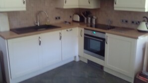A kitchen with white cabinets, a stainless steel sink, a built-in oven, and a microwave. - Comfortable Barn, Ashdown Forest, Fantastic Local Pub, Excellent For Walkers (Danehill, Haywards Heath)