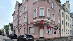 Un edificio rosa con múltiples ventanas y un letrero que dice 'Vinum'.