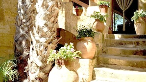 A stone staircase with potted plants, leading to a door with a striped curtain. - CALM - ZENITUDE - ONE OF THE MOST BEAUTIFUL HOUSES OF GOZO (GHARB)