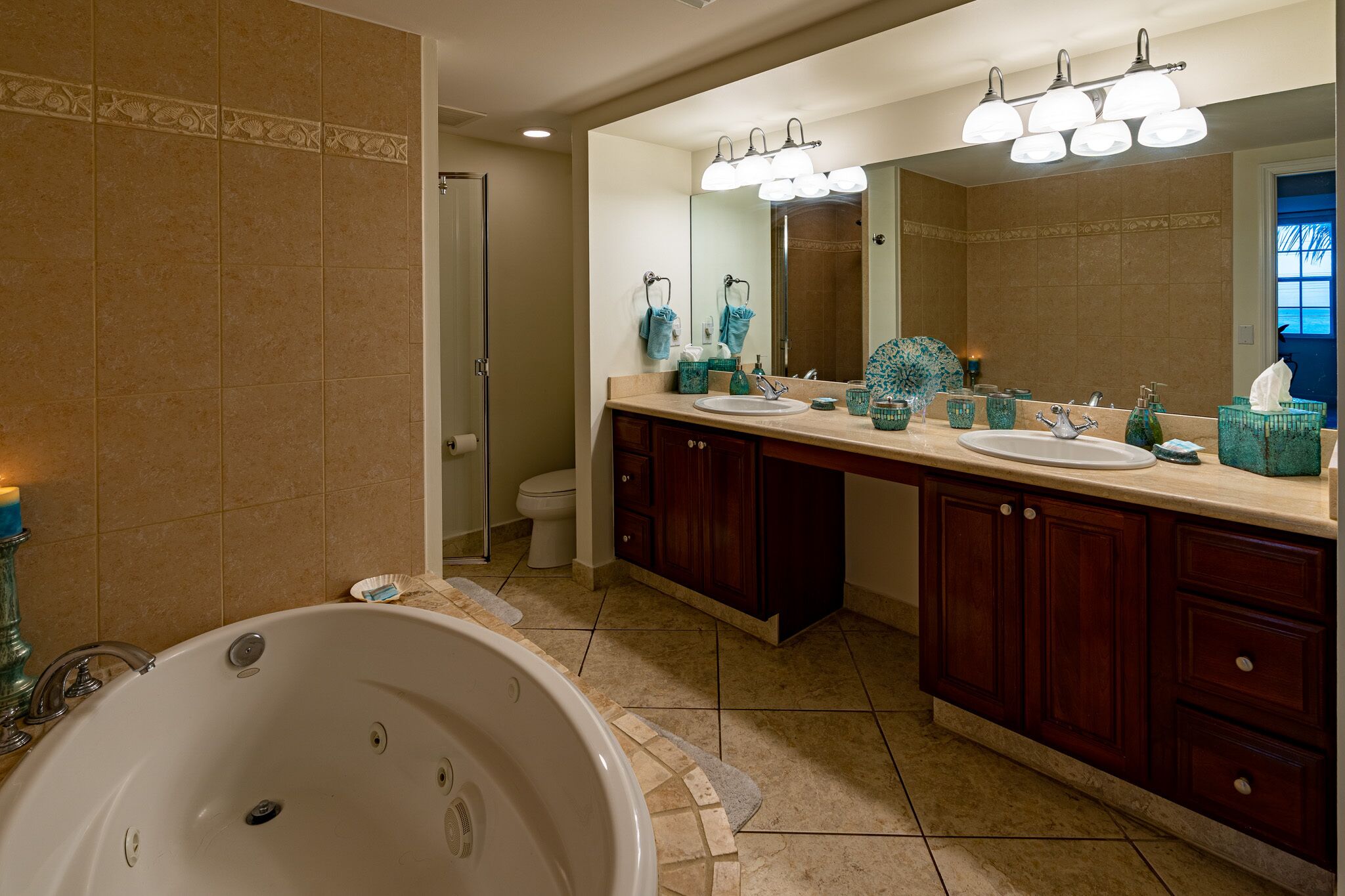 Un baño con una bañera grande, dos lavamanos y un mueble de tocador con armarios.