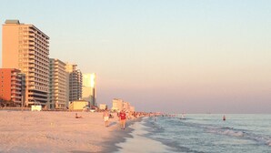A beach with buildings in the background. - Beautiful Condo Steps to the Gulf!  (Gulf Shores)