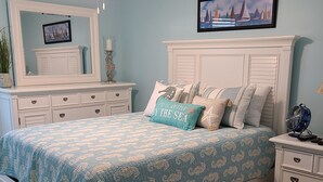 A bedroom with a bed, dresser, nightstand, and a ceiling fan. - Beautiful Condo Steps to the Gulf!  (Gulf Shores)