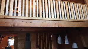 A wooden balcony with vertical railings, a window with blinds, and a door with a vent. - Sugarloaf Cabin sweet cabin (Big Bear)