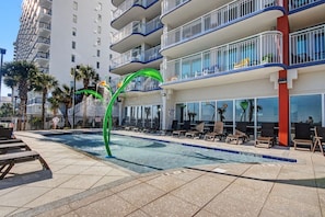 A hotel pool area with lounge chairs and a decorative arch. - 4BR/3BA, Sleeps 16, Large Oceanfront, Balcony (Myrtle Beach)