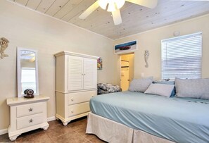A bedroom with a bed, dresser, and a mirror.