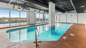 An indoor swimming pool with clear views of the surrounding landscape through large windows. - Gorgeous Recently Updated 3rd Floor Direct Beachfront Condo Perfect Location (Gulf Shores)