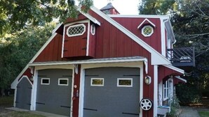 A red barn-style house with two garage doors and a small porch.