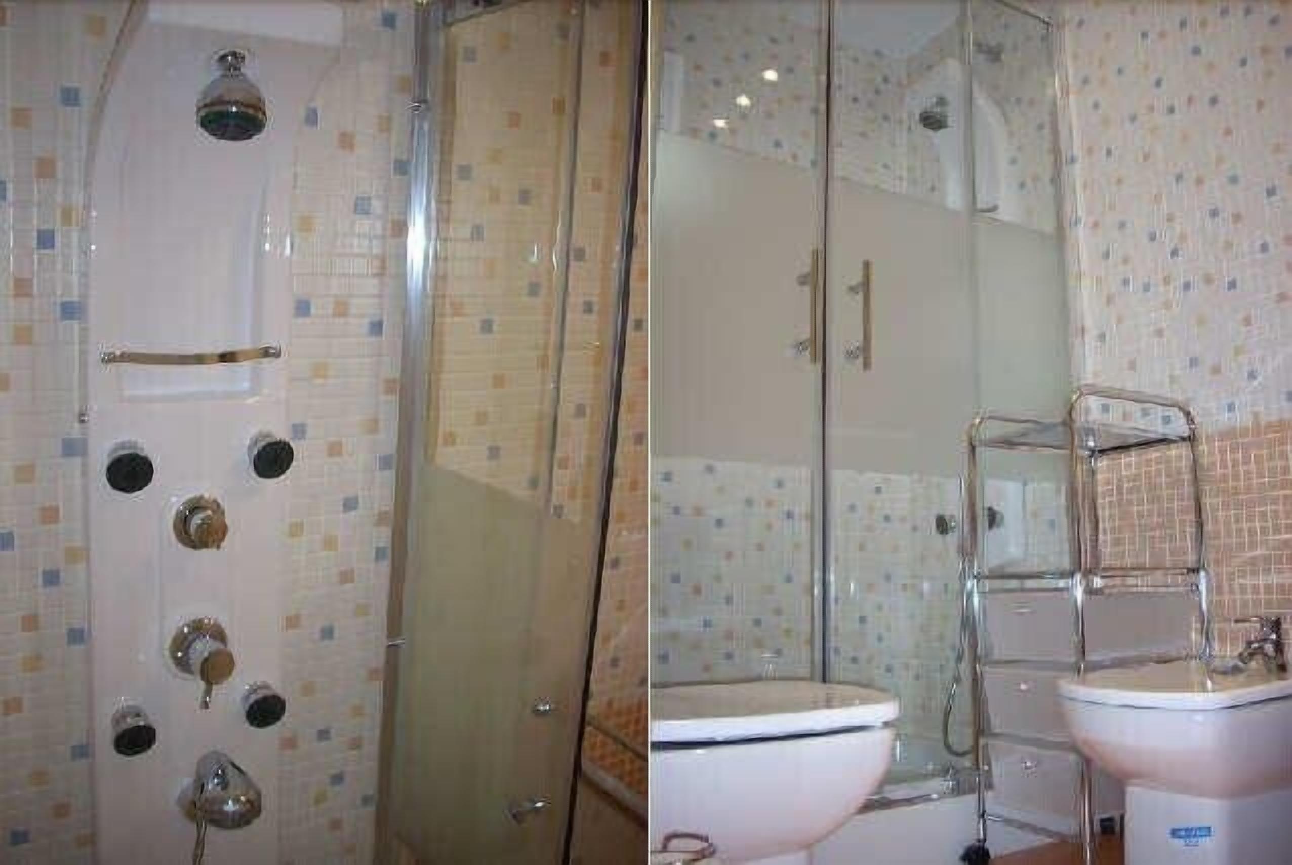 Een badkamer met een douche met glazen wanden, een wit toilet en een wastafel met een chromen kraan.