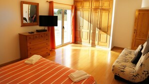 A bedroom with a bed, a TV, a dresser, and a wardrobe. - Casa do Mar by Laranjal Rentals (Albufeira)