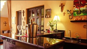 A bar area with a reflective surface, a sink, and a painting of trees. - Ochenta Y Dos an urban bed & breakfast (Mérida)