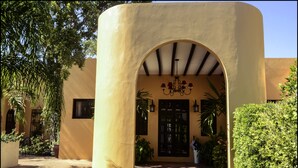 A building with a yellow facade, a central archway, and a chandelier. - Ochenta Y Dos an urban bed & breakfast (Mérida)