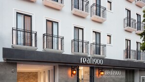A modern building with a sign reading "reahgoo" indicating a hotel, cafe, and terrace bar. - Real 1900 (Iguala de la Independencia)