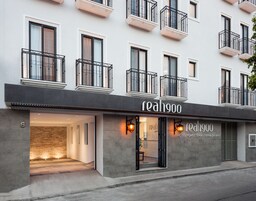 Un edificio moderno con un letrero que dice "reahgoo", indicando un hotel, cafetería y bar terraza.