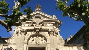 Un edificio histórico con intrincados relieves y un arco central.