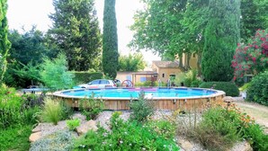 Una piscina rodeada por un jardín con diversas plantas y flores.